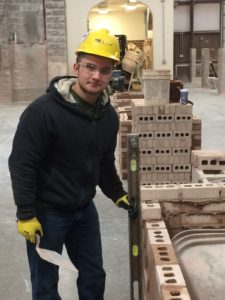 Johnathon Crouch, aprendiz de albañil con un sindicato de albañiles de Connecticut, construye un muro como parte de su capacitación.